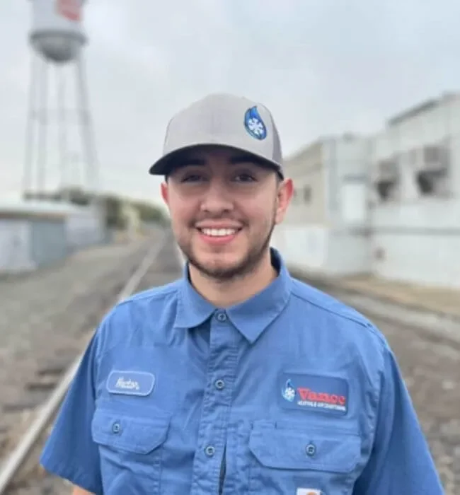 Photo of smiling technician in front of train tracks